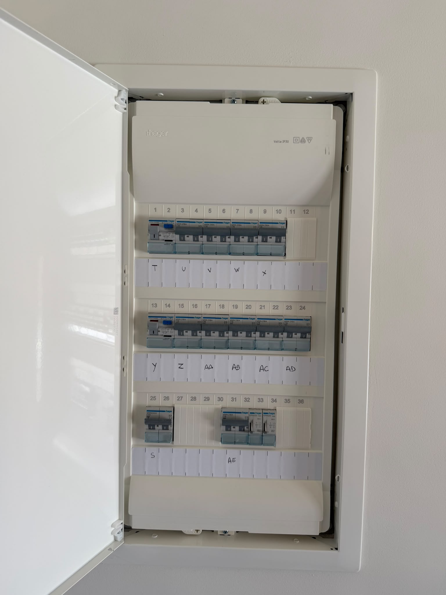 Tableau électrique encastré dans le mur, disjoncteurs numérotés et étiquetés