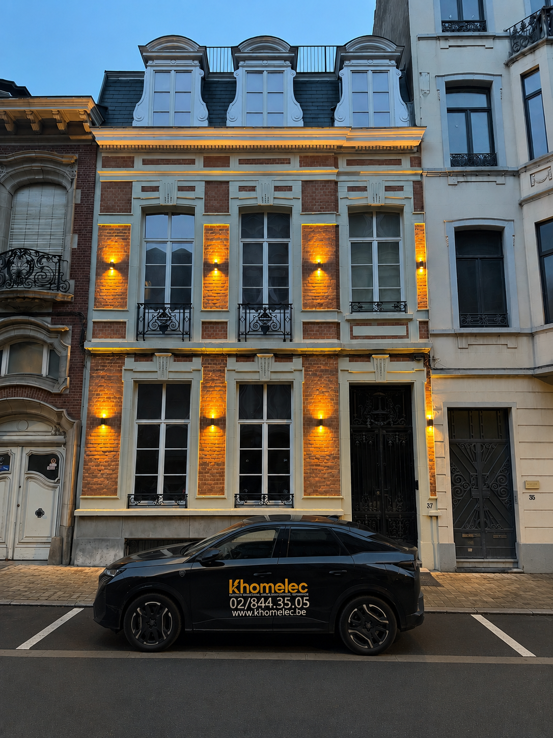 Véhicule KHOMELEC devant une façade bruxelloise mise en valeur par un éclairage LED installé par nos soins